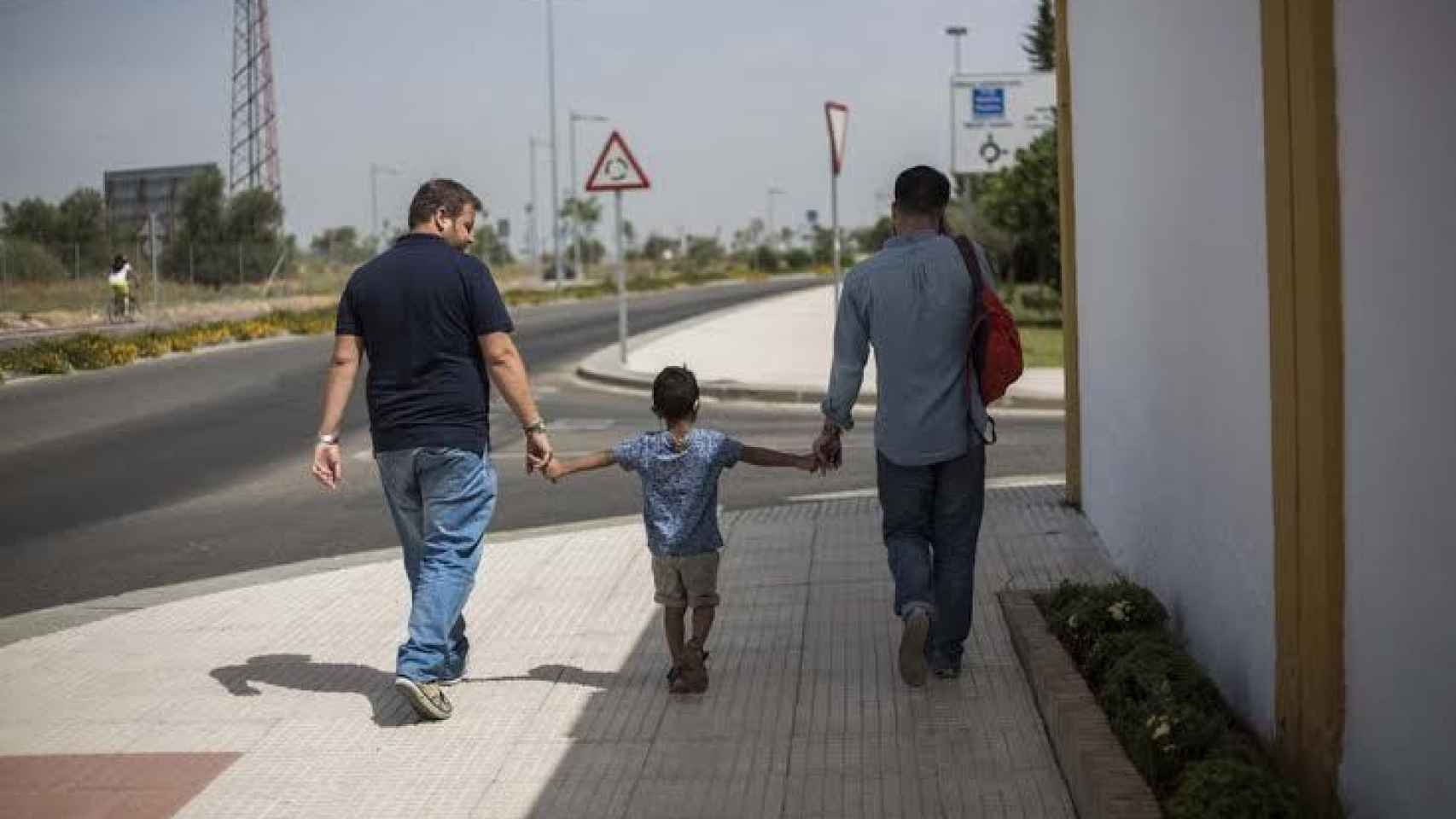 Julián y Agustín, caminando junto a su hijo por su pueblo.