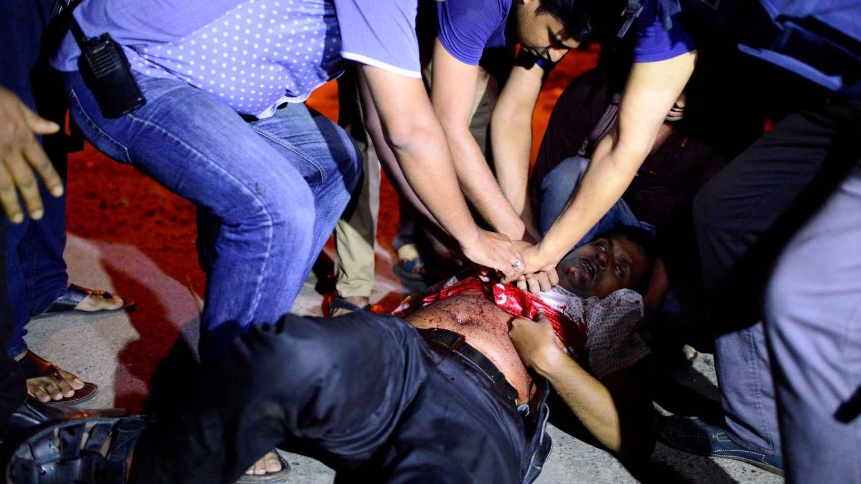 Los efectivos de emergencia tratan de ayudar a una persona herida durante la toma de rehenes en Daca.