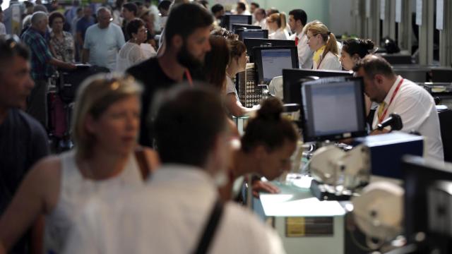 Personal de facturación de Vueling atiende a los viajeros en el Aeropuerto de El Prat