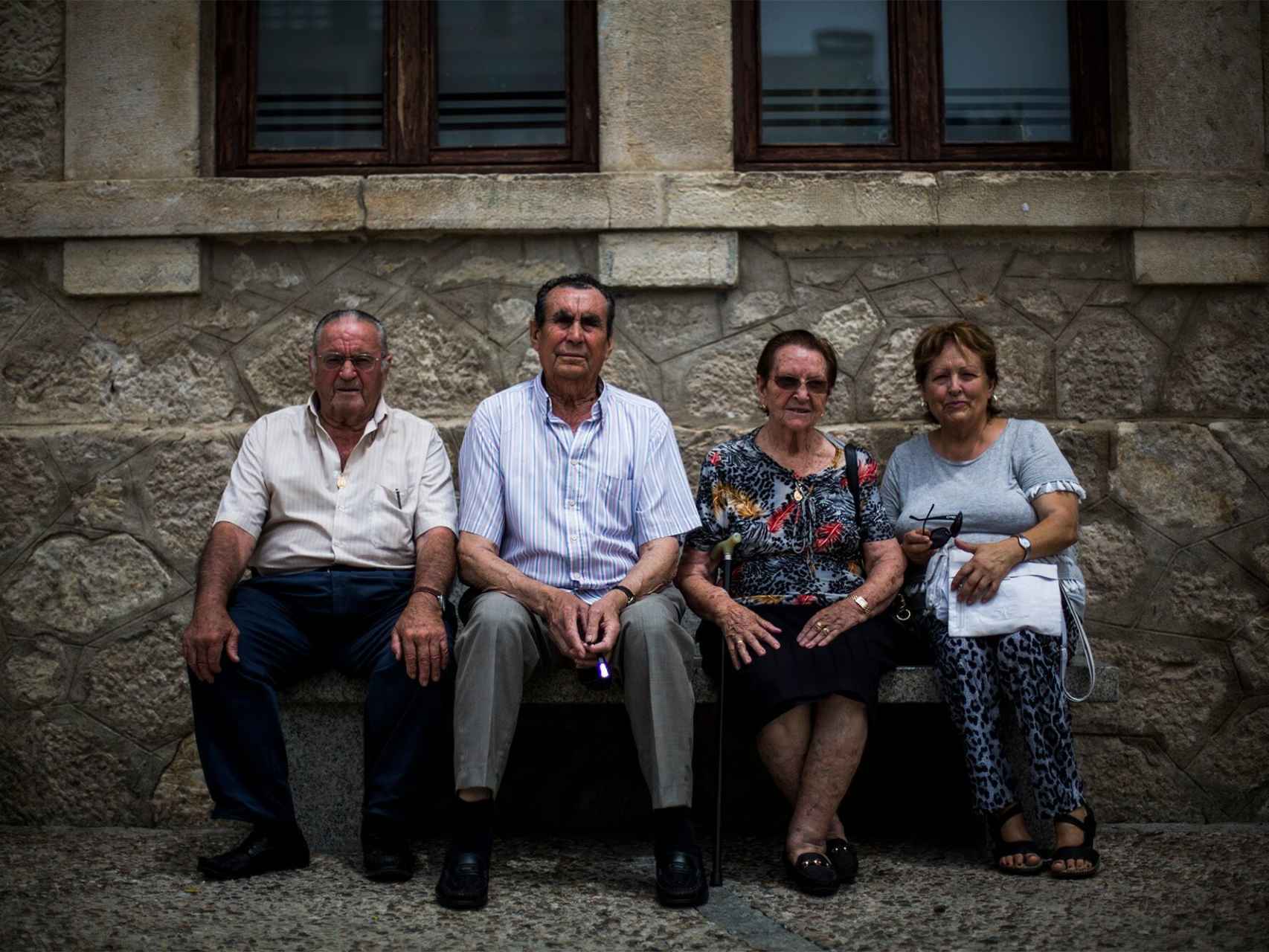 Los cuatro vecinos de Guadalix de la Sierra que participaron en el rodaje posan en un banco.