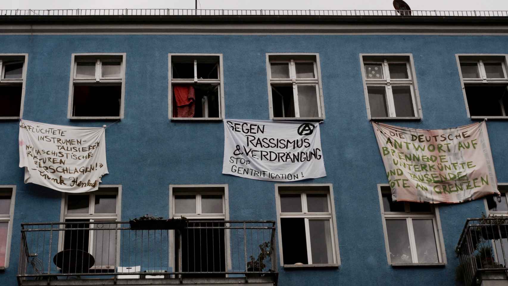 - Contra el racismo y la represión, reclama una de las pancartas de la fachada okupa.