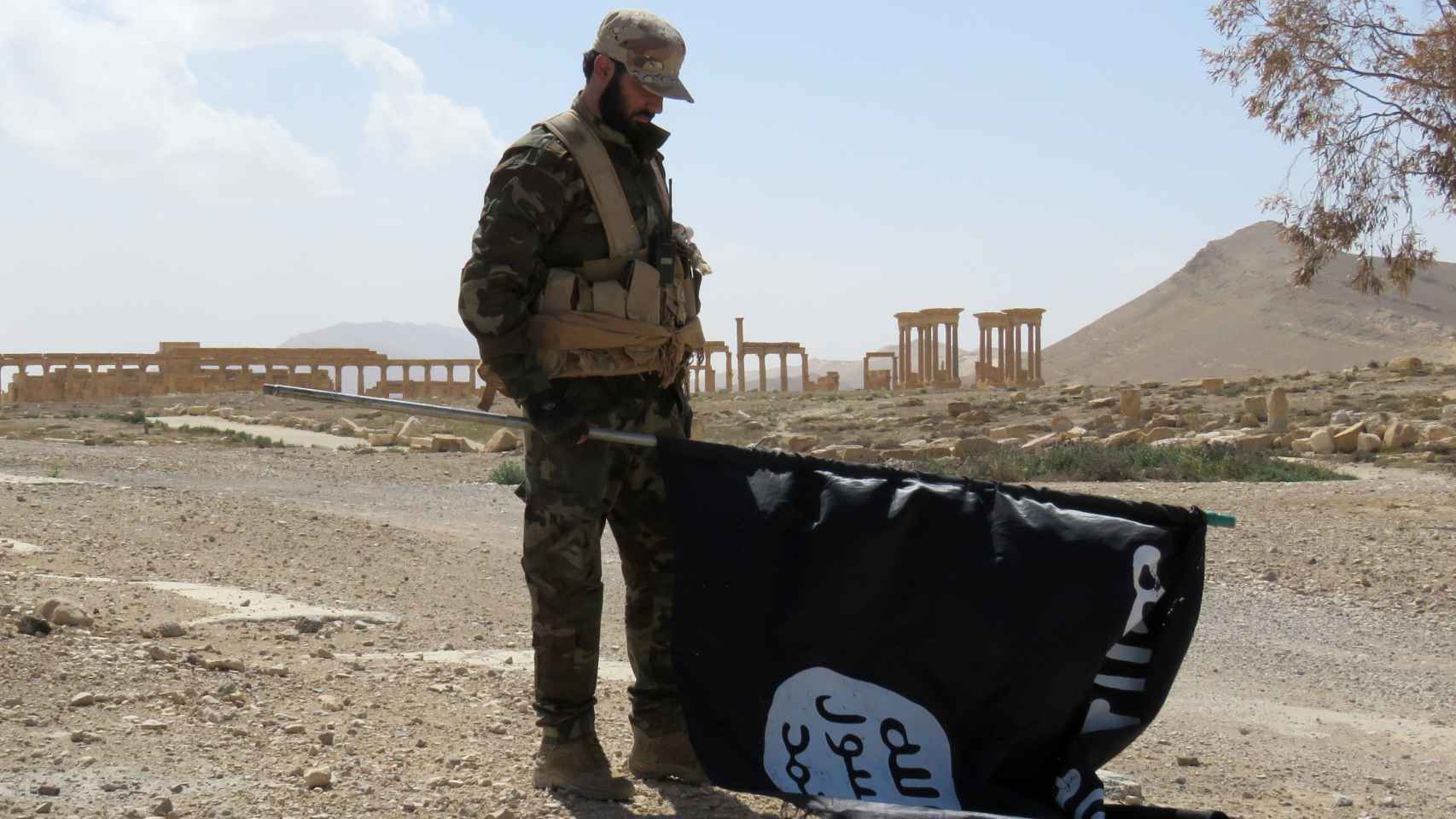 Un soldado sirio retira una bandera del Estado Islámico en Siria.