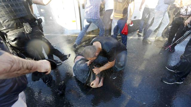 Dos soldados se protegen en el suelo de la acción de los ciudadanos.