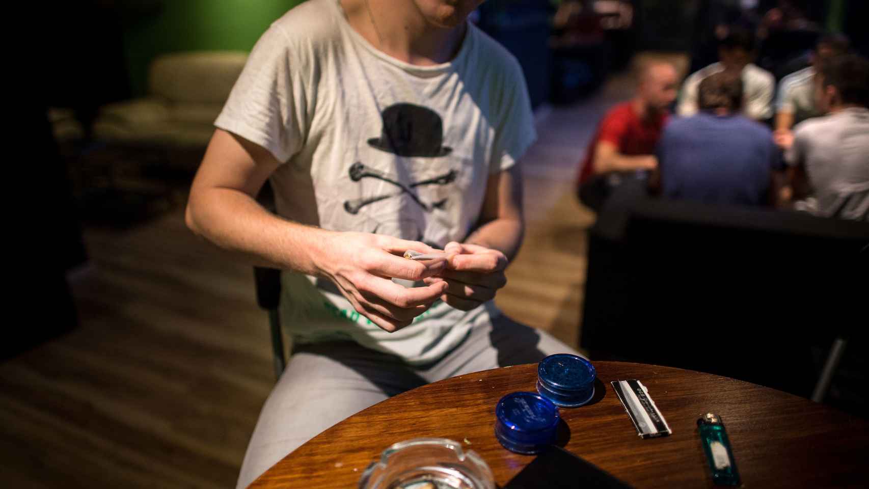 Un joven liando un porro de cannabis