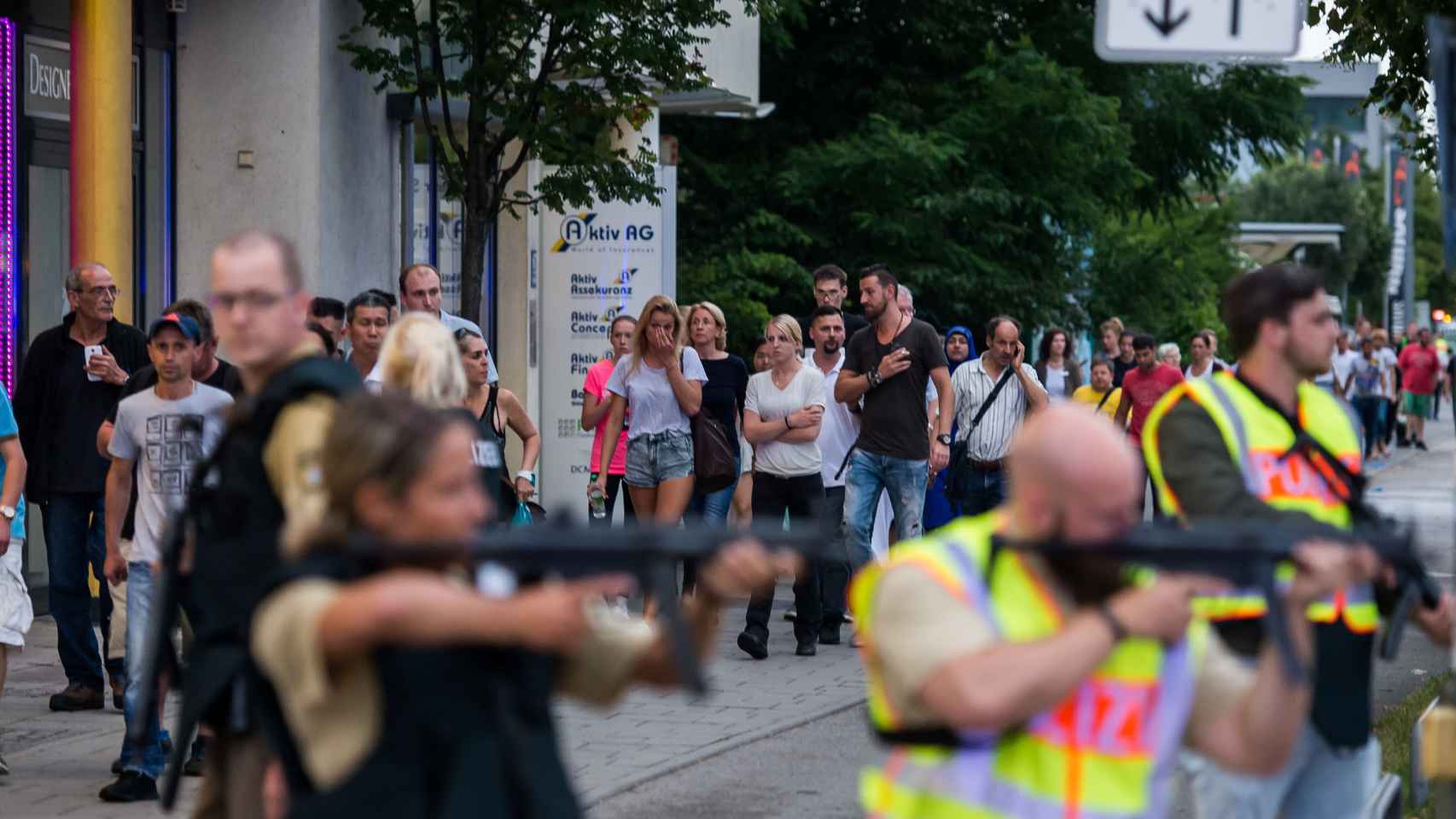Un grupo de ciudadanos espera en las afueras del centro comercial Olympia durante el tiroteo.