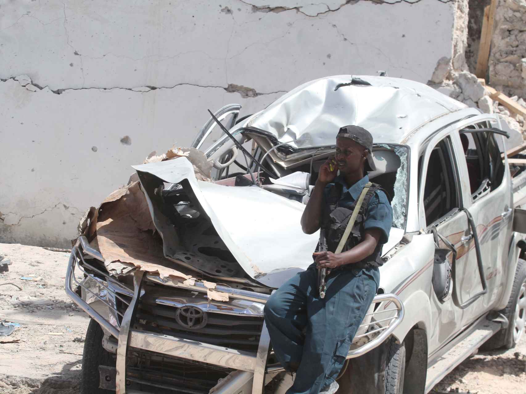Un policía apoyado en un coche destruido tras la explosión.