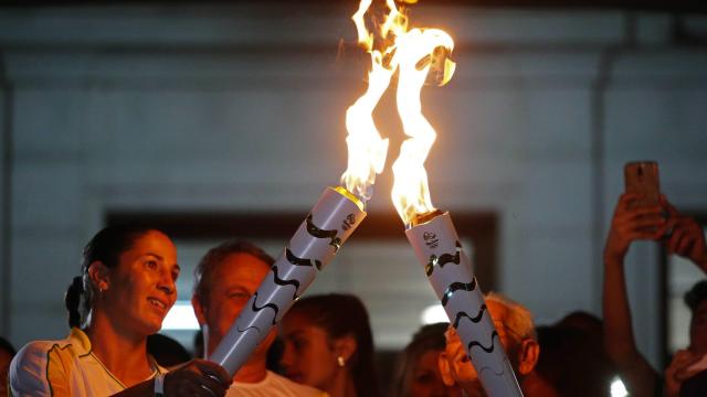 Dos atletas se dan el relevo en de la antorcha olímpica en Río.