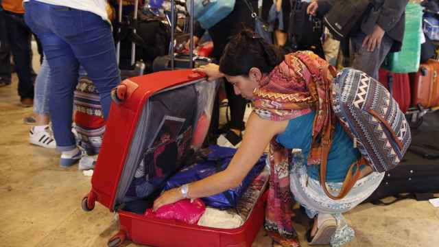 Una mujer abre su maleta en el aeropuerto.