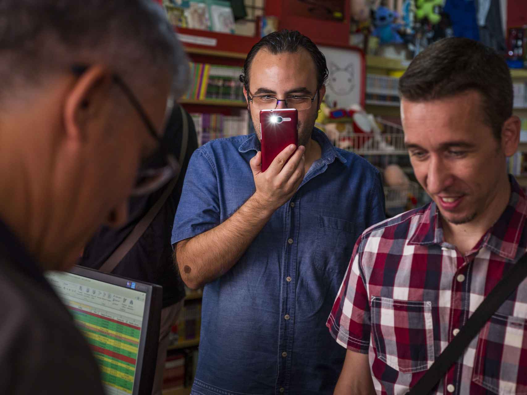 El periodista y actor de doblaje, Jose Antonio Gavira, firmando un recuerdo a uno de los seguidores de Bola de Dragón, mientras es fotografiado por el móvil de otro de ellos.