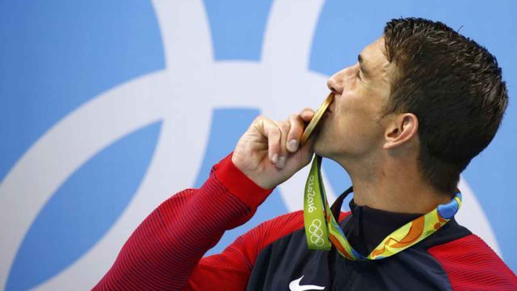 Phelps besa su nueva medalla de oro.