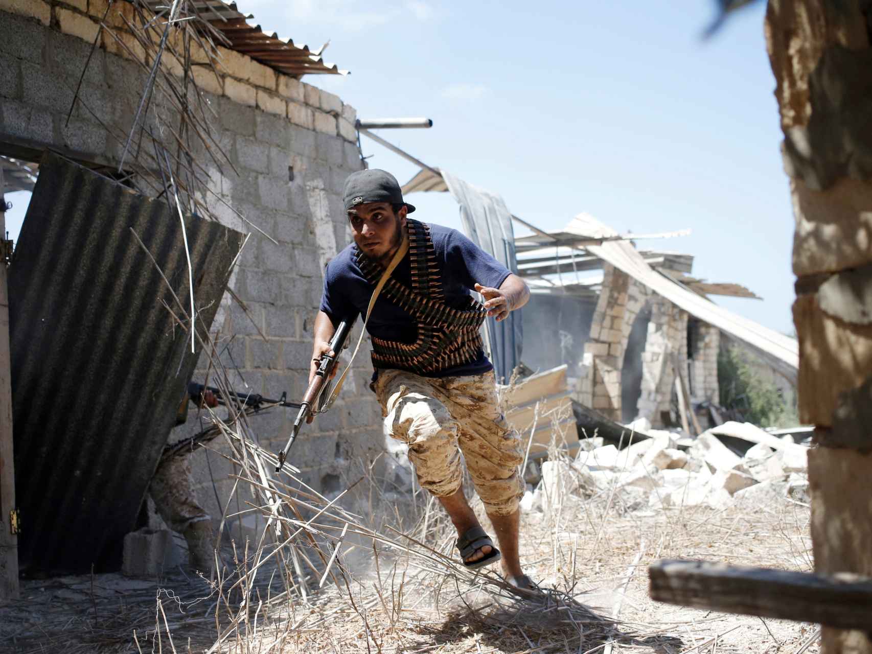 Un soldado libio intenta cubrirse en la batalla por Sirte.