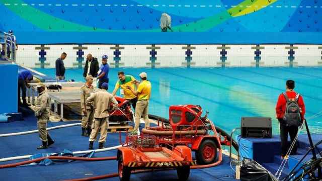 Operarios de Río cambian el agua de la piscina.