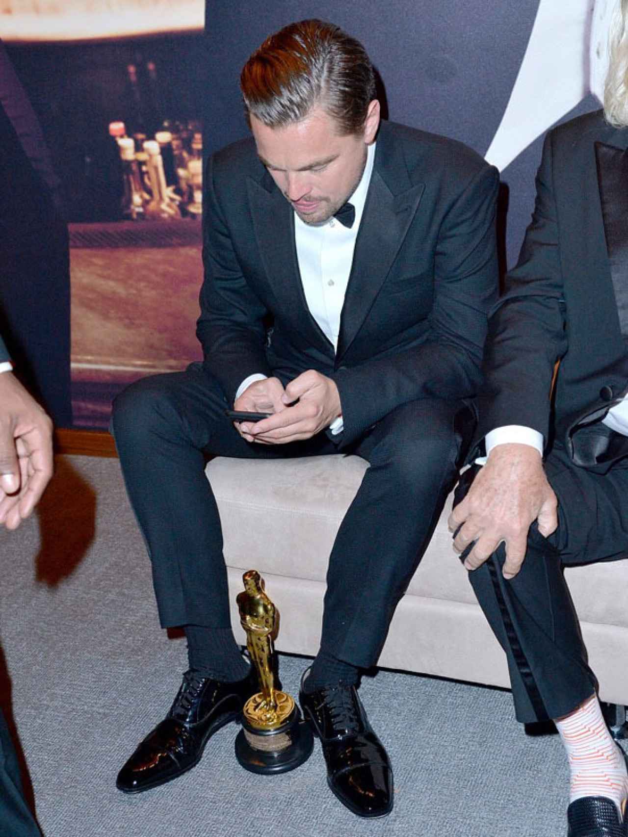 Leonardo DiCaprio muy atento del móvil en la fiesta tras la gala de los Oscar.