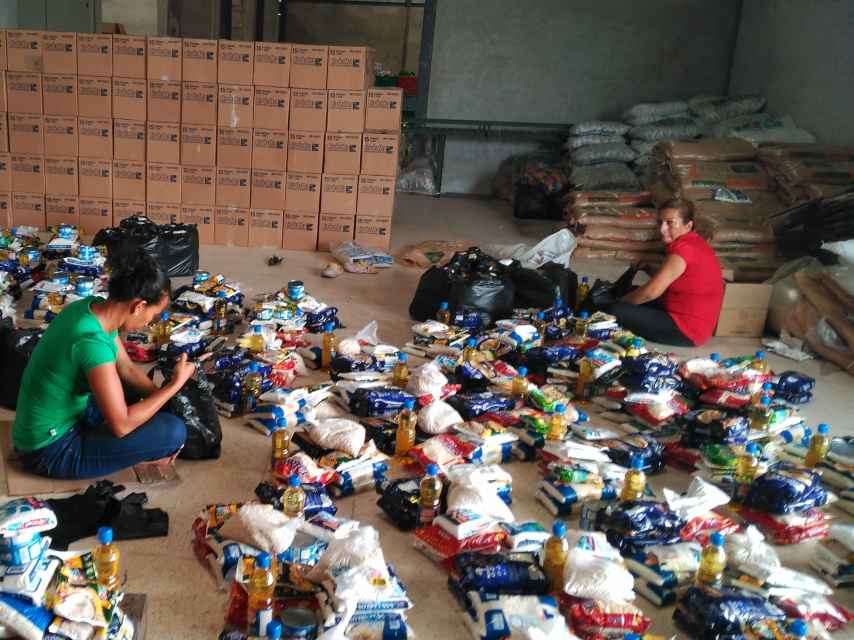 Varias mujeres de la asociación se dedican a hacer bolsas de comida para las familias.