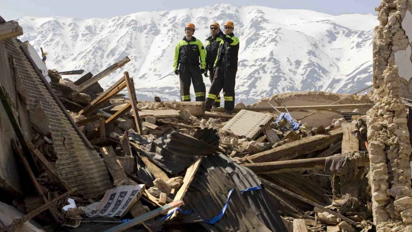 Bomberos registrando entre los escombros de un edificio en la ciudad de L'Aquila (centro).