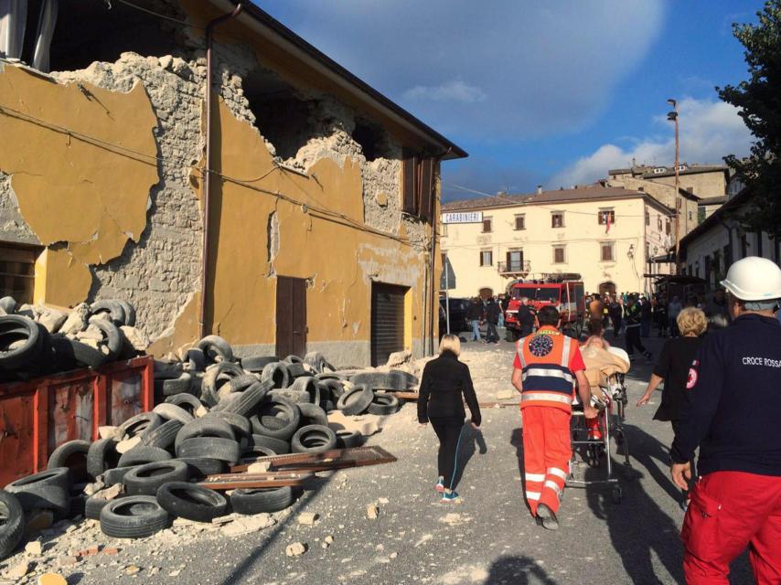 Los equipos de rescate caminan entre las ruinas de Accumoli di Rieti tras el terremoto.