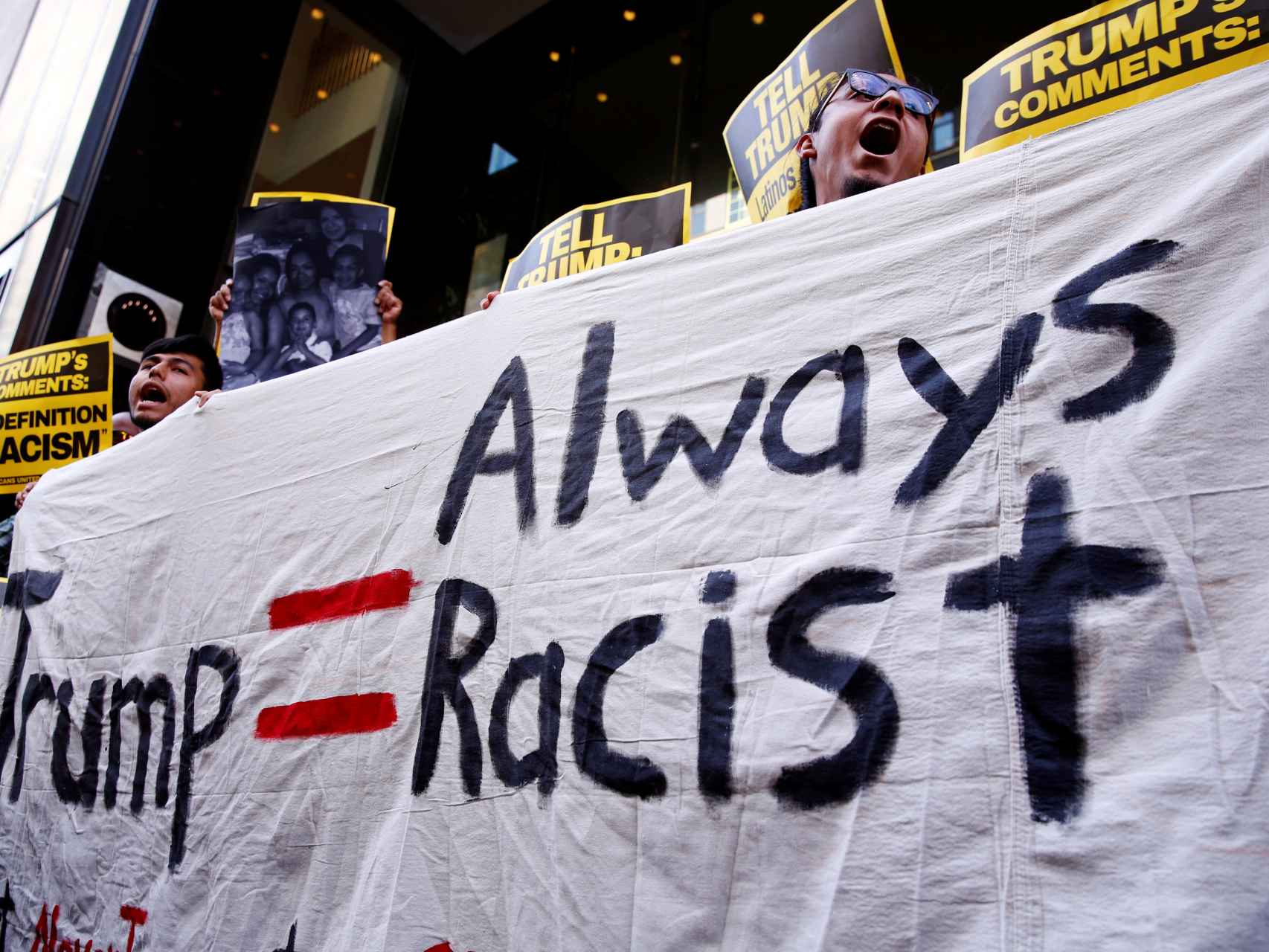 Varios manifestantes protestan contra Trump llamándole racista.