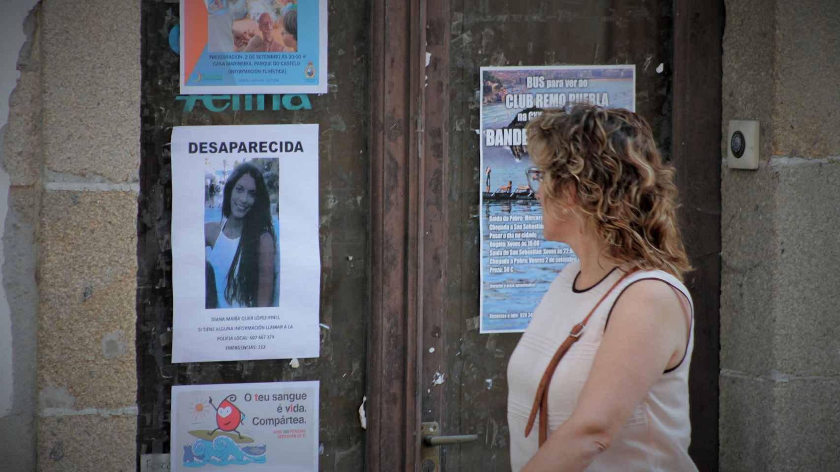 Una mujer pasa junto a un cartel con sobre Diana Quer en A Pobra.