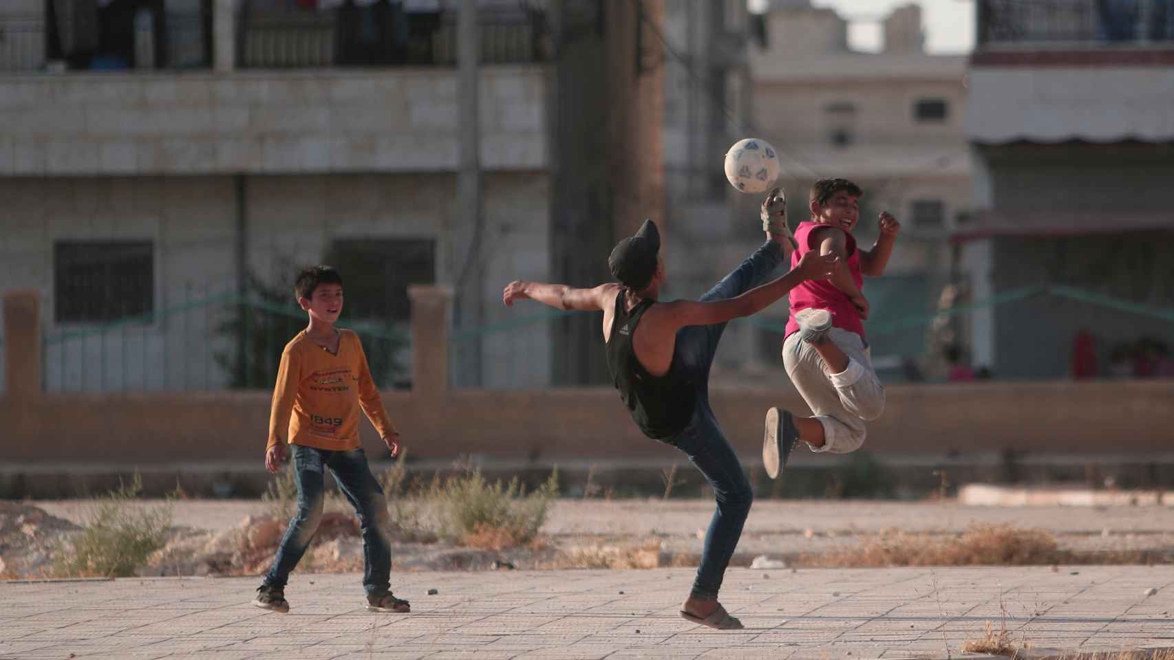 Varios niños juegan al fútbol en las calles de Alepo (Siria).