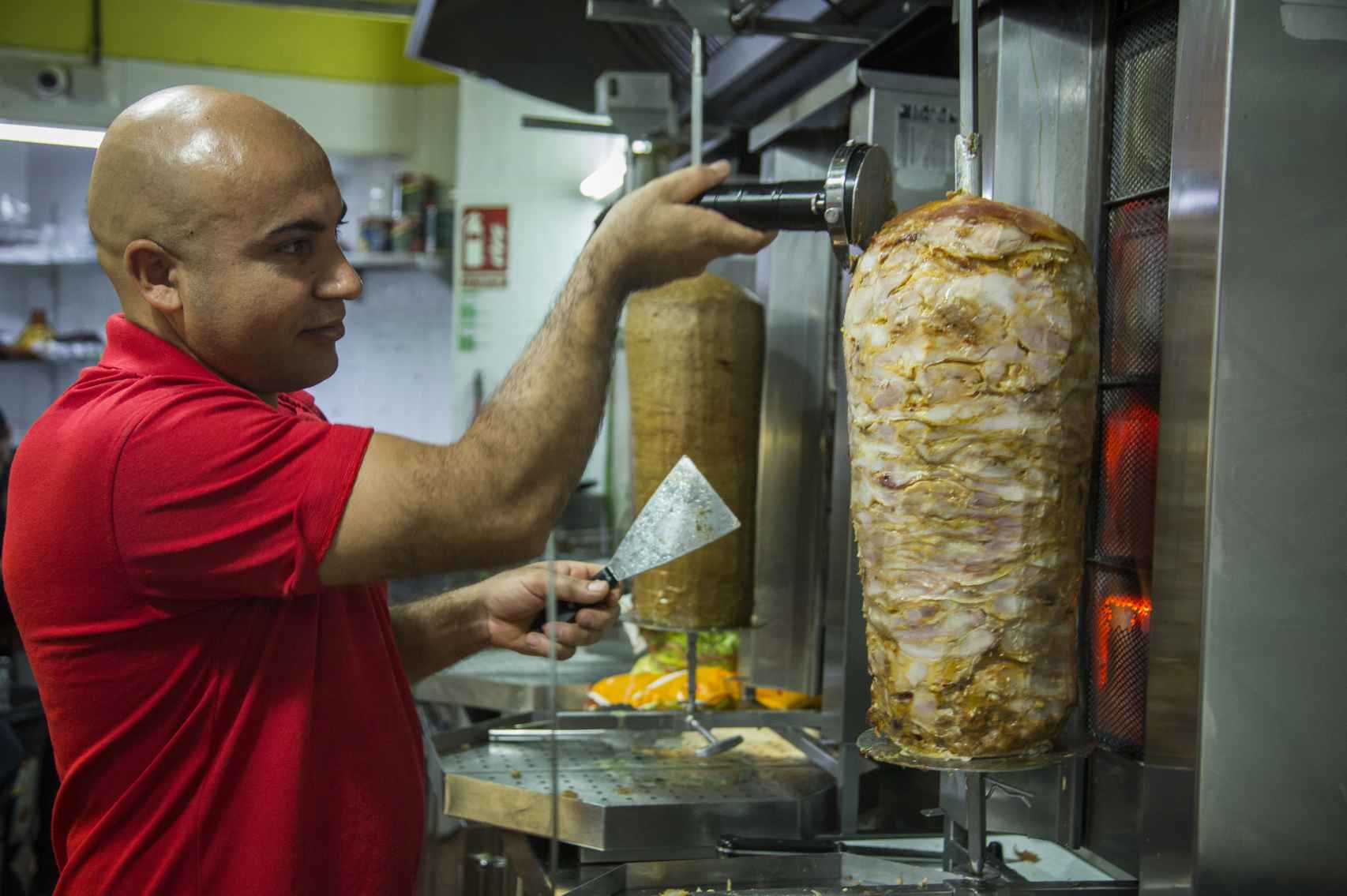 Hokman Joma, refugiado kurdo de Siria, trabajando en el primer restaurante de comida rápida, que abrió en Sevilla, El Zapatazo.