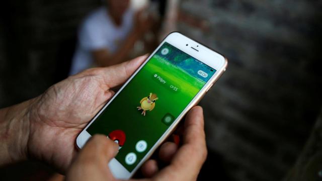 Un hombre jugando a Pokemon Go en su móvil.