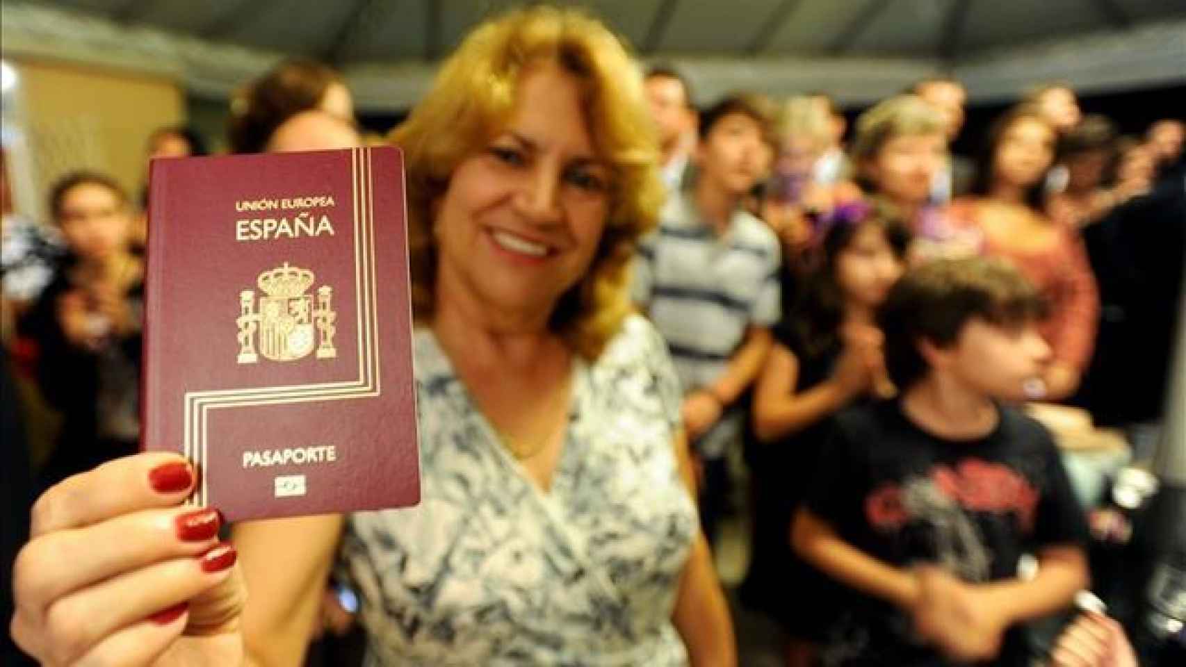 Una mujer brasileña muestra su pasaporte español.