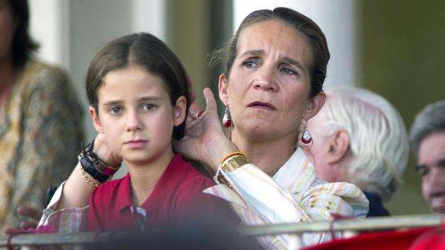 La infanta Elena recoge cariñosamente la melena de su hija.