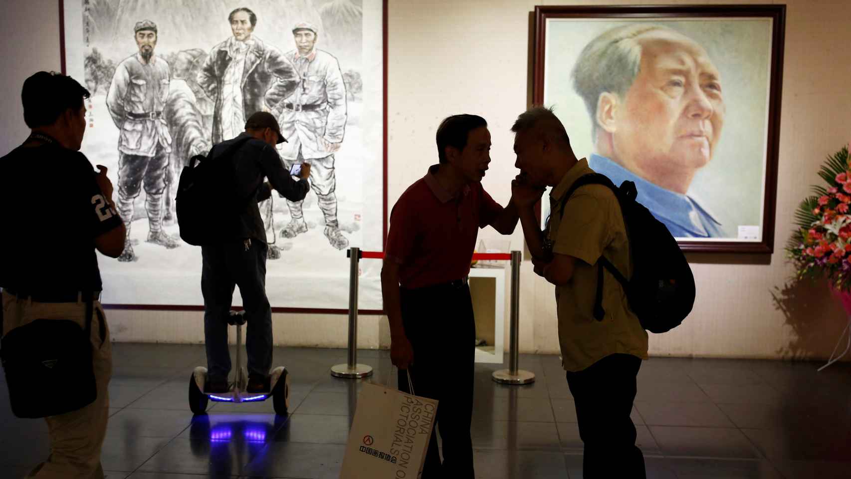 Visitantes ante ilustraciones de Mao Zedong en una exhibición en Pekín. REUTERS/Thomas Peter