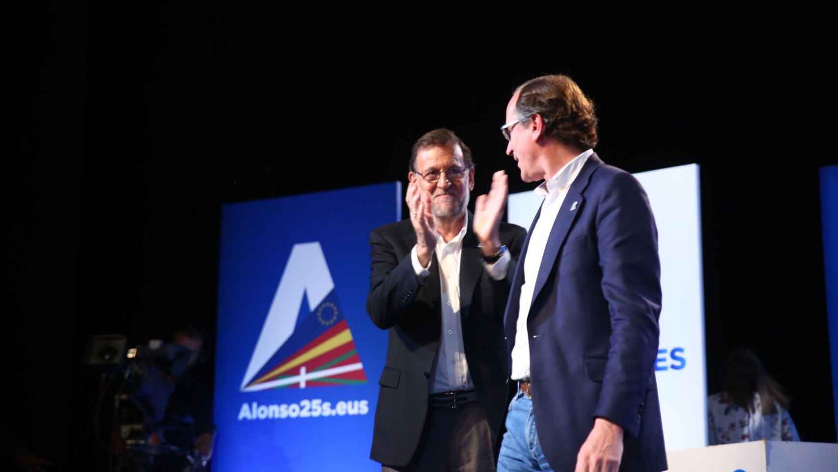 Rajoy aplaude a Alonso tras su mitin.