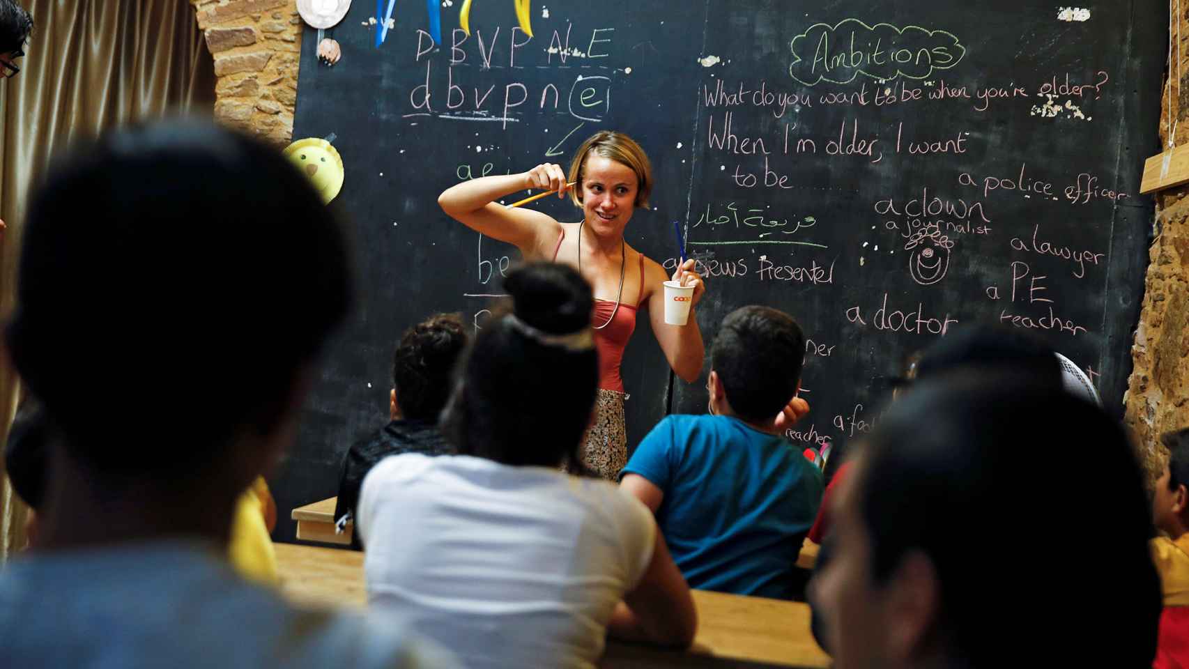 Voluntaria británica impartiendo clase a refugiados en Grecia.