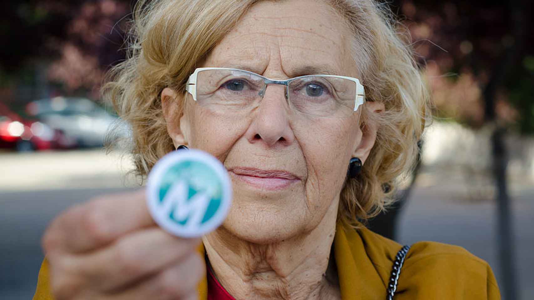 Manuela Carmena muestra un pin de su partido/ Wikimedia Commons