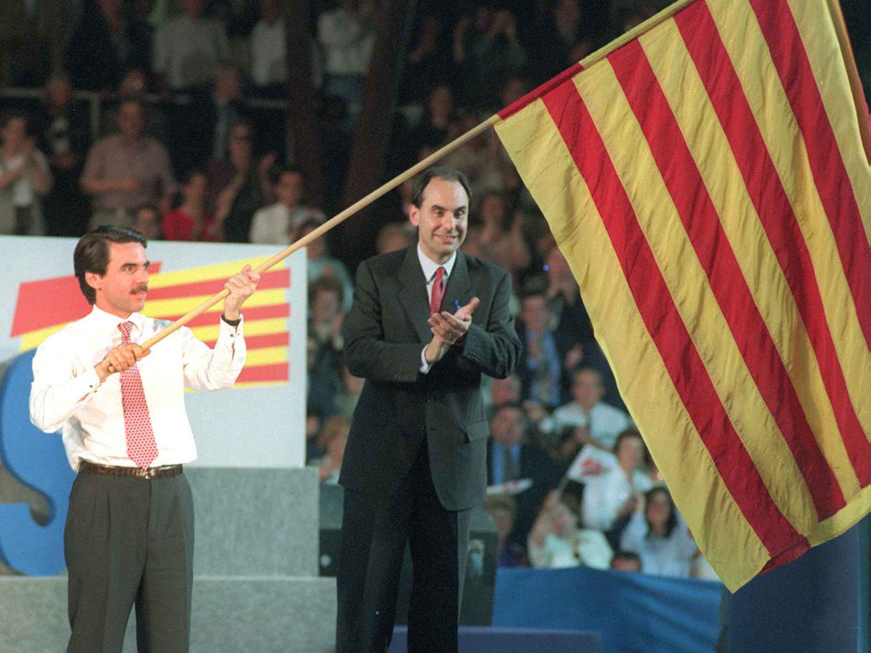 José María Aznar enarbola una bandera catalana junto al entonces presidente del partido en Cataluña.