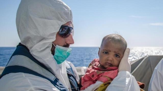 Un efectivo de la Armada con un bebé rescatado en marzo de 2016.