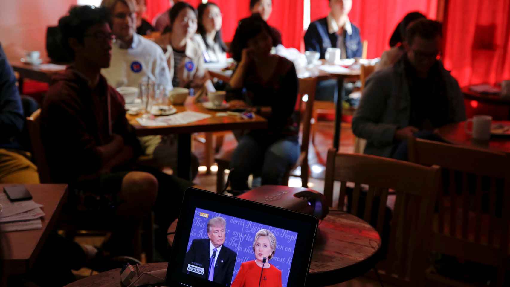 Un espectador, en un bar, sigue el debate de Clinton-Trump por la tablet.
