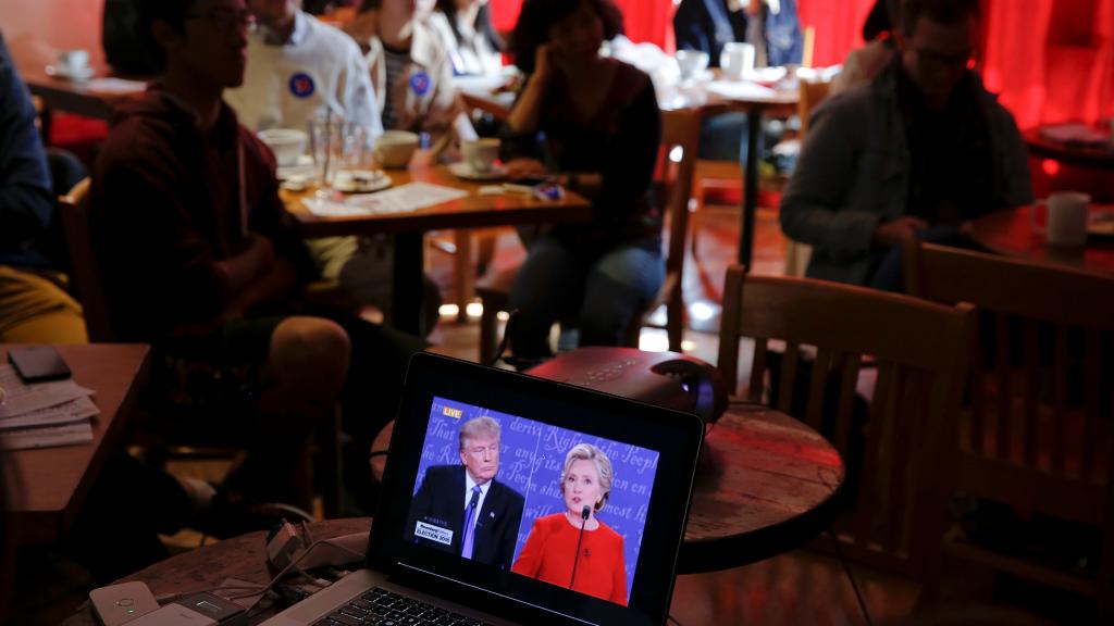 Un espectador, en un bar, sigue el debate de Clinton-Trump por la tablet.