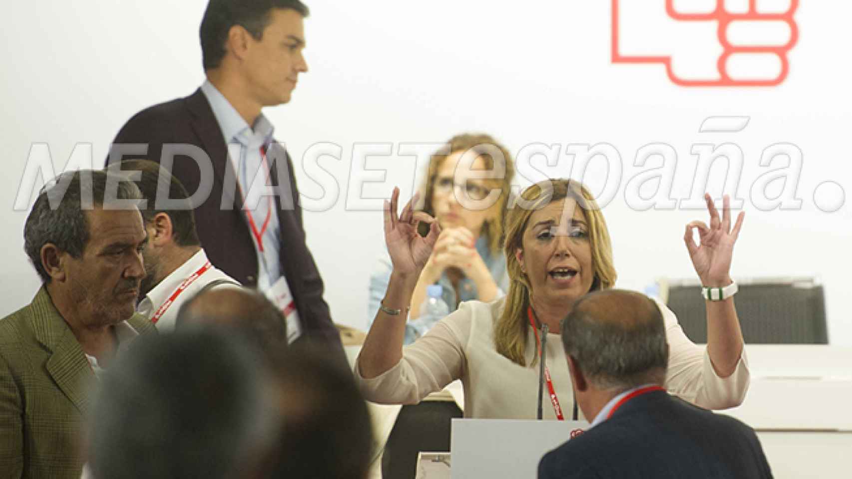 Susana Díaz toma la palabra mientras Pedro Sánchez pasa por detrás.