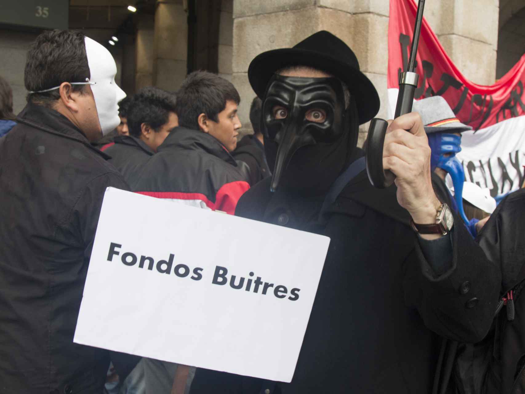 Un hombre porta un cartel contra los fondos buitre durante la manifestación