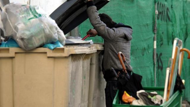 Un hombre busca en un contenedor.