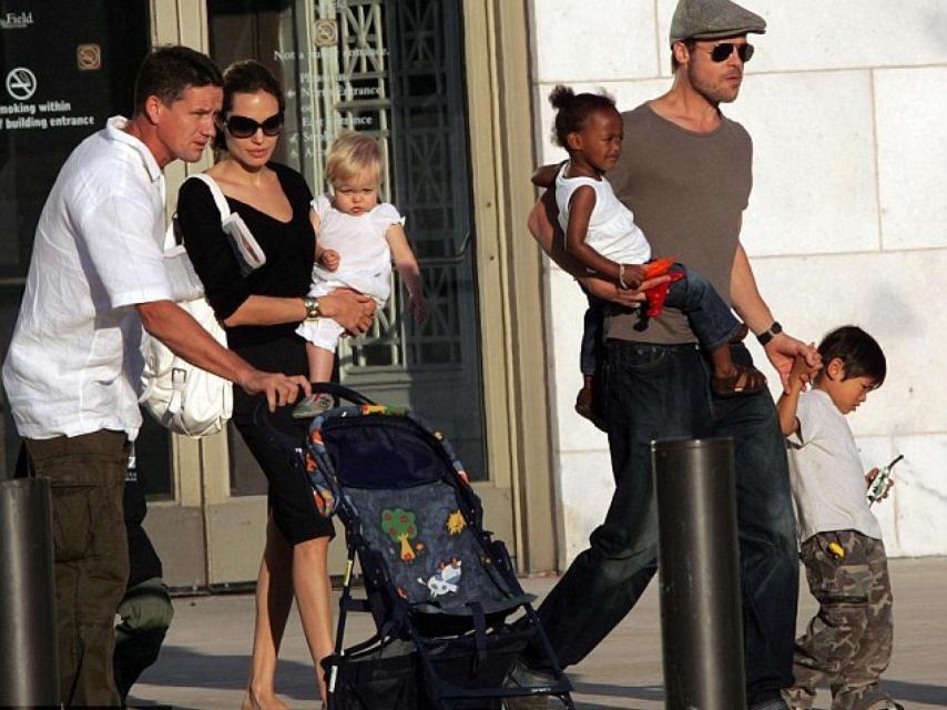 La familia y su guardaespaldas, Billy, llevando el carrito del bebé.