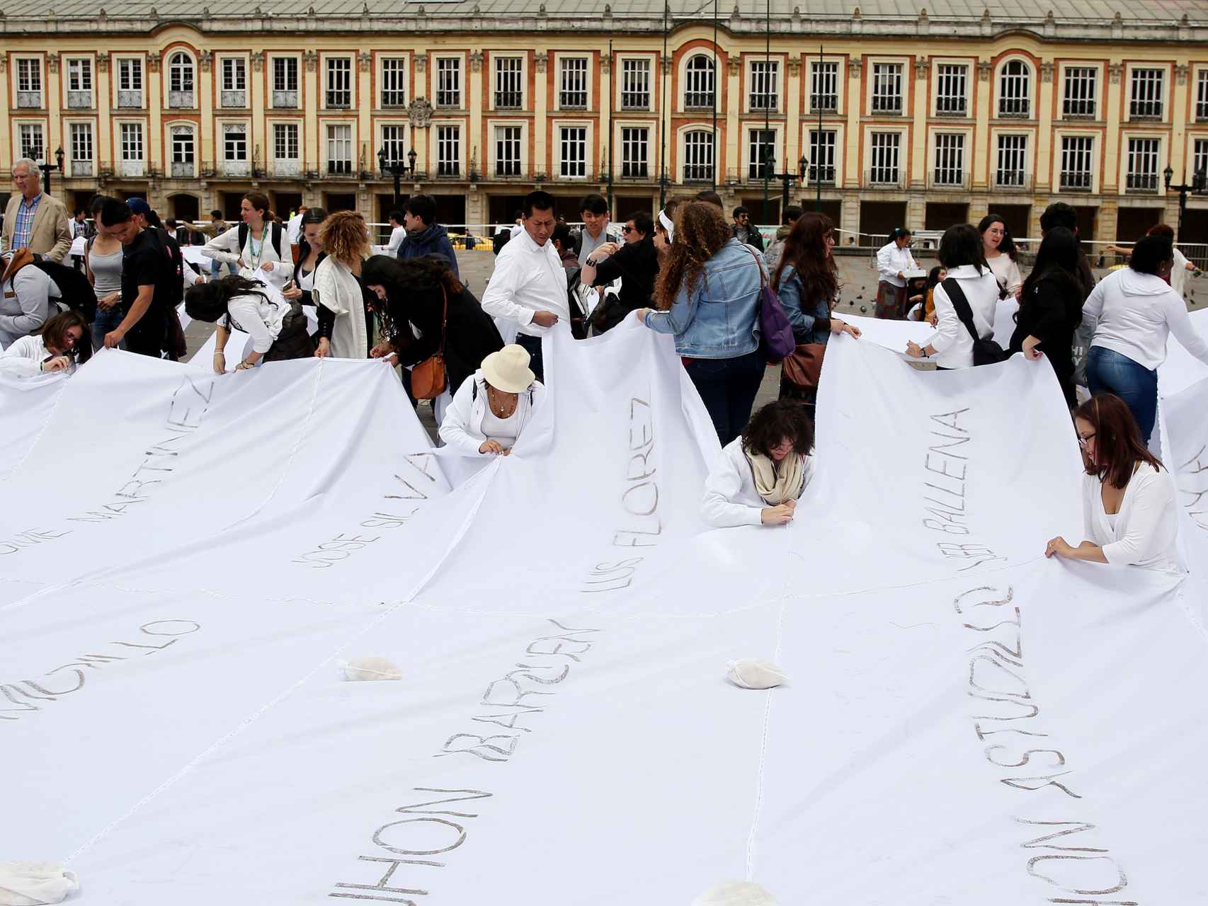 Un grupo de personas participa en una intervención artística liderada por la colombiana Doris Salcedo.