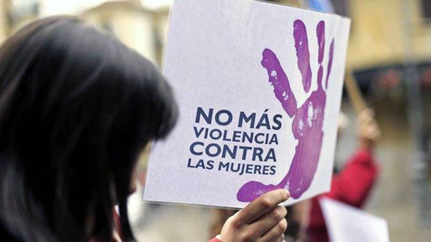 Una mujer porta una pancarta en contra de la violencia machista.