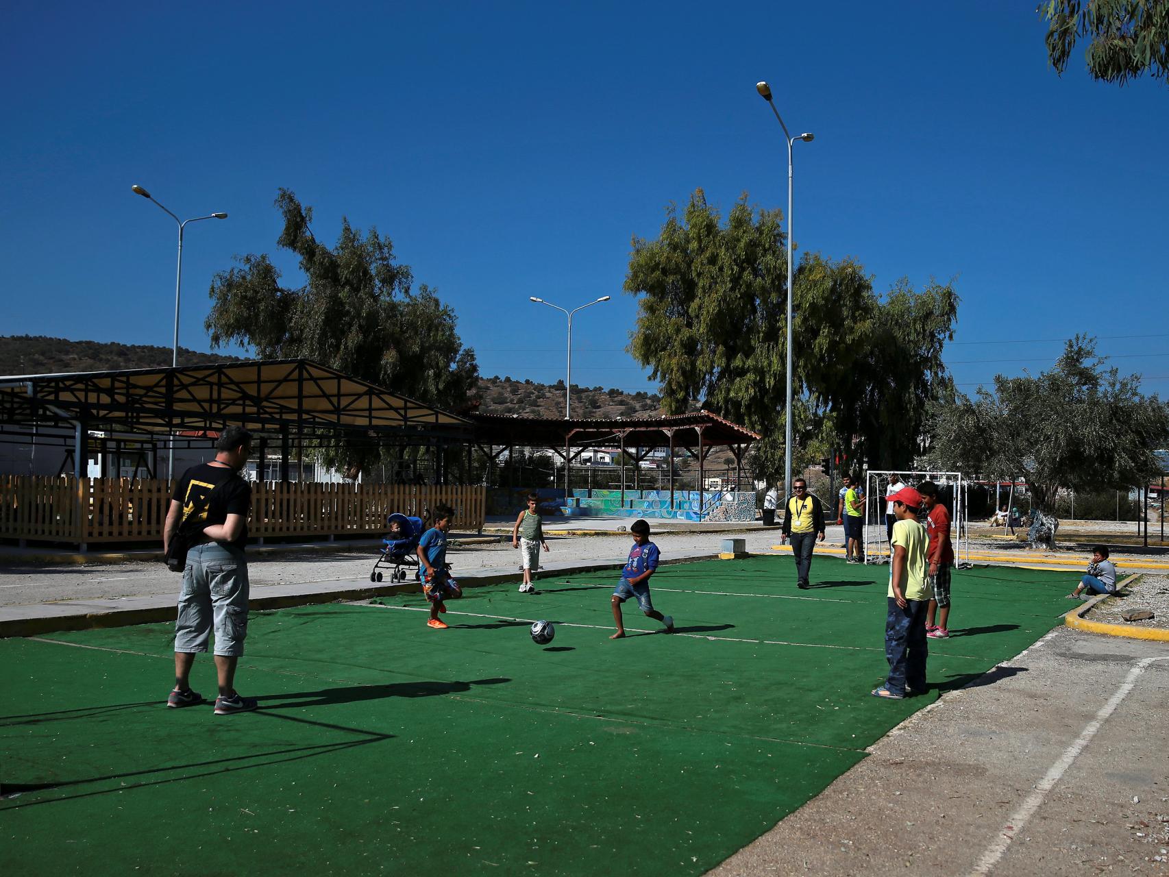 Voluntarios juegan al fútbol con refugiados en un campamento.