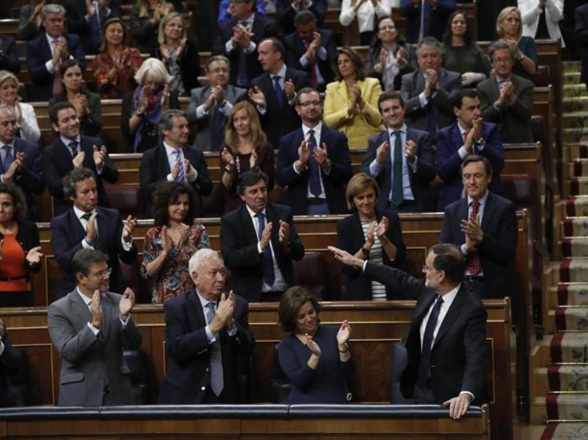 Rajoy, aplaudido por el resto de diputados del PP, saluda en el Congreso este jueves.