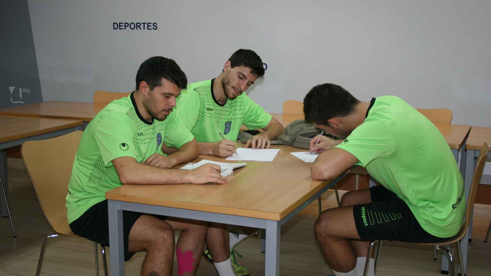 Juanra, Miguel Conde y  Miguel Fernández estudian antes de entrenar.