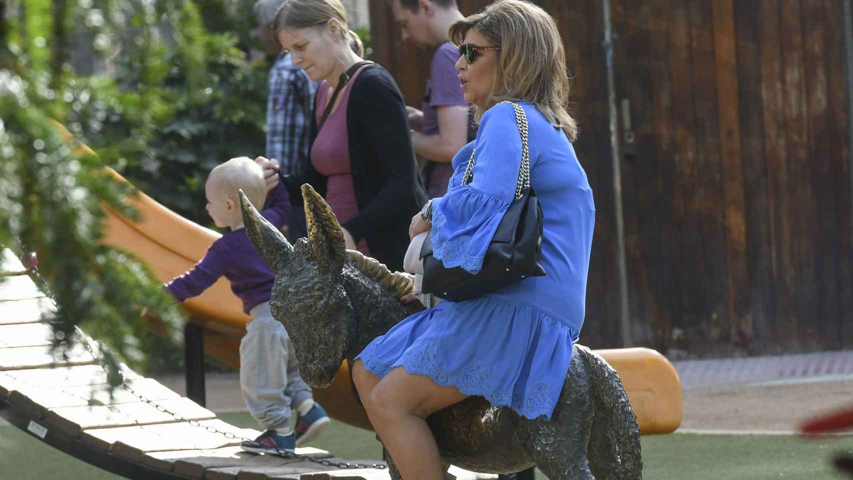 Terelu Campos montada en una escultura en forma de burro durante el rodaje