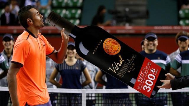 Kyrgios simula beber una botella gigante de vino.