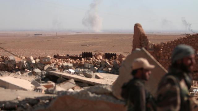 Rebeldes sirios cerca de un edificio bombardeado al norte de Raqa