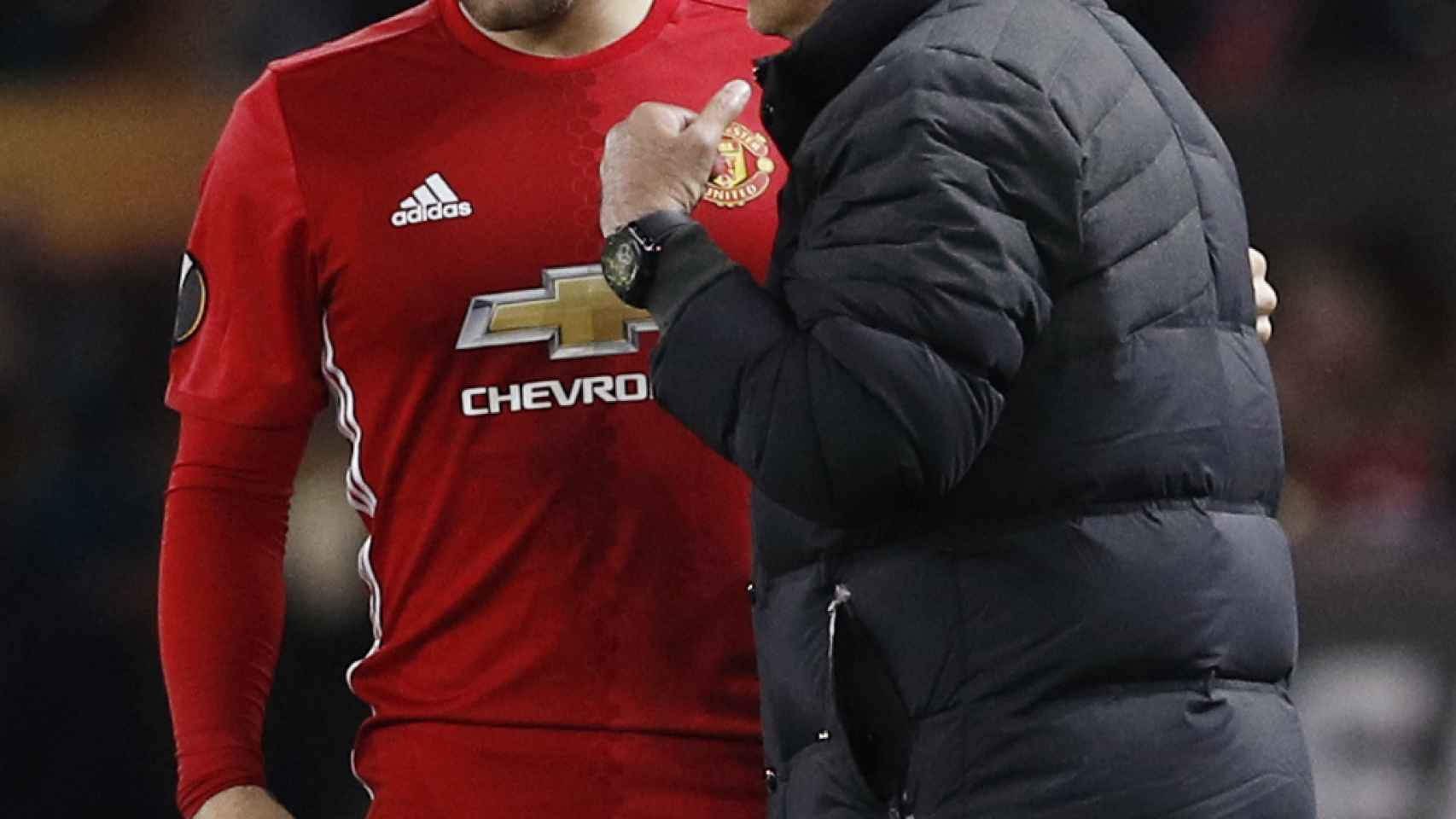 Mourinho conversa con Luke Shaw durante un partido.
