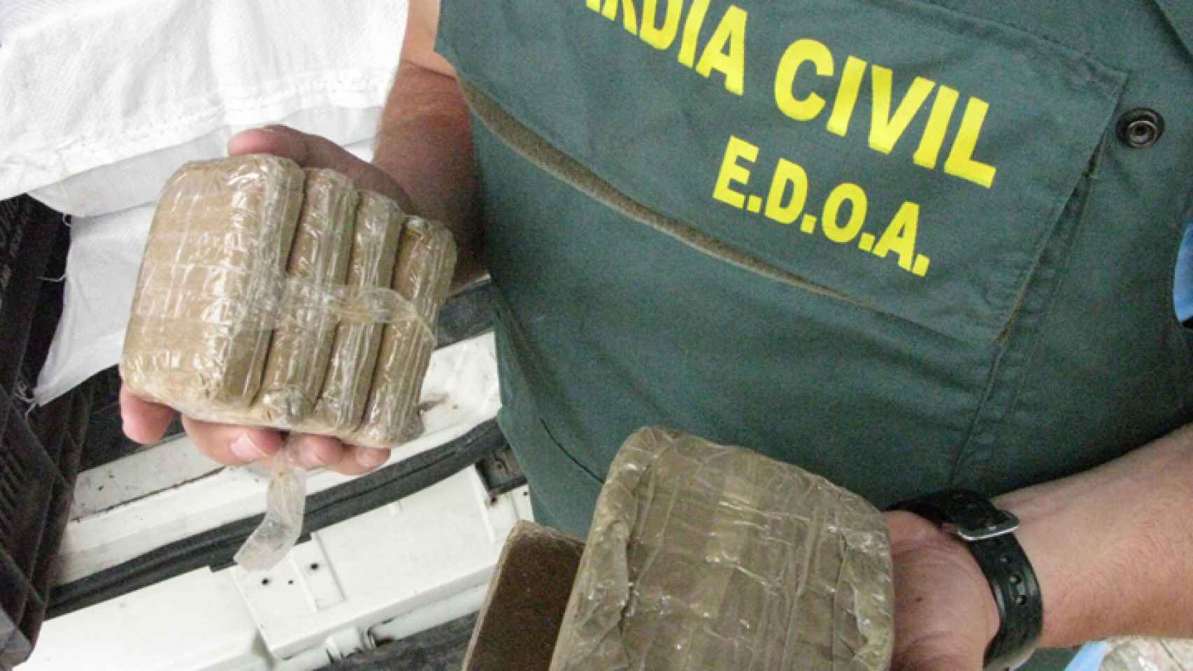 Un agente del EDOA sostiene varias placas de hachís decomisadas durante un operativo de la Benemérita.