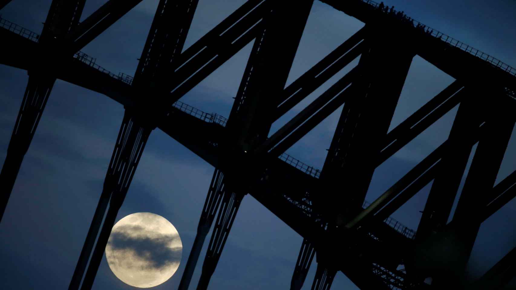 Visitantes contemplan la superluna desde lo alto del puente de Sydney.